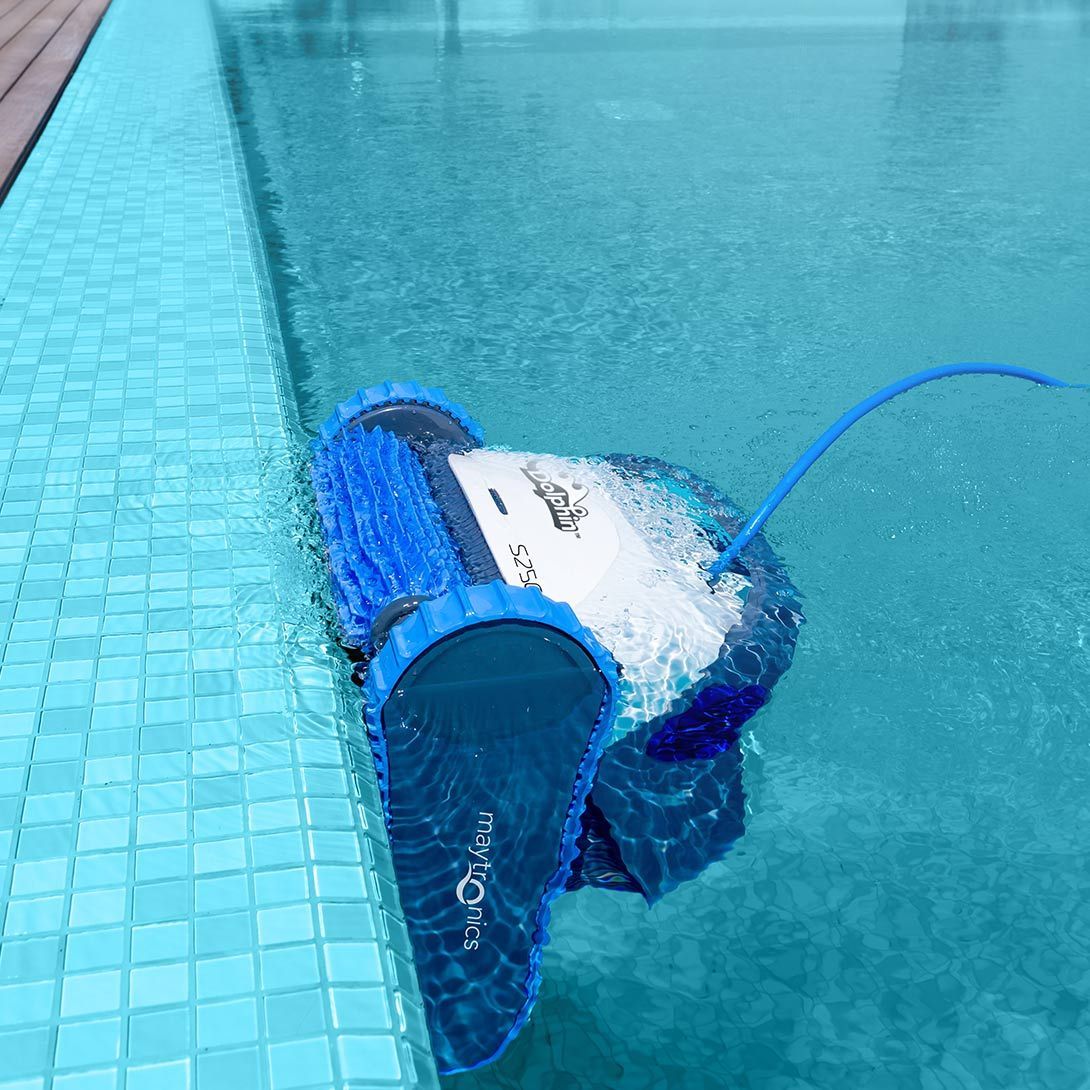 Blue Robotic Pool Vacuum Floating in A Swimming Pool Beside the Tiled Edge — Manning Pools, Rubber & Foam In Taree, NSW