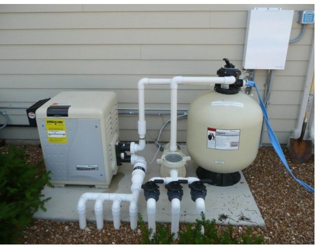 A Swimming Pool Filter Is Attached To The Side Of A House — Manning Pools, Rubber & Foam In Taree, NSW
