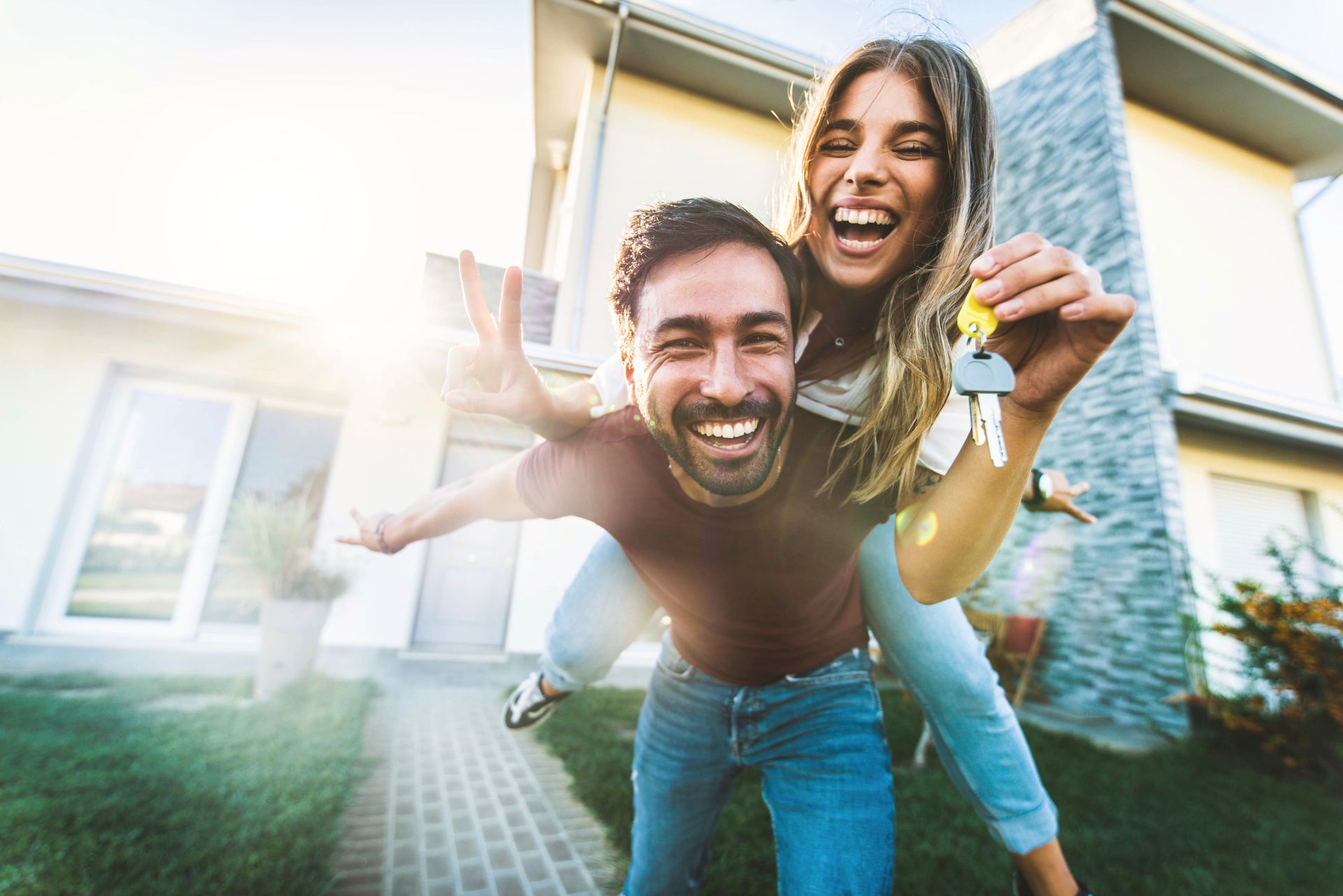 a man is carrying a woman on his back in front of a house