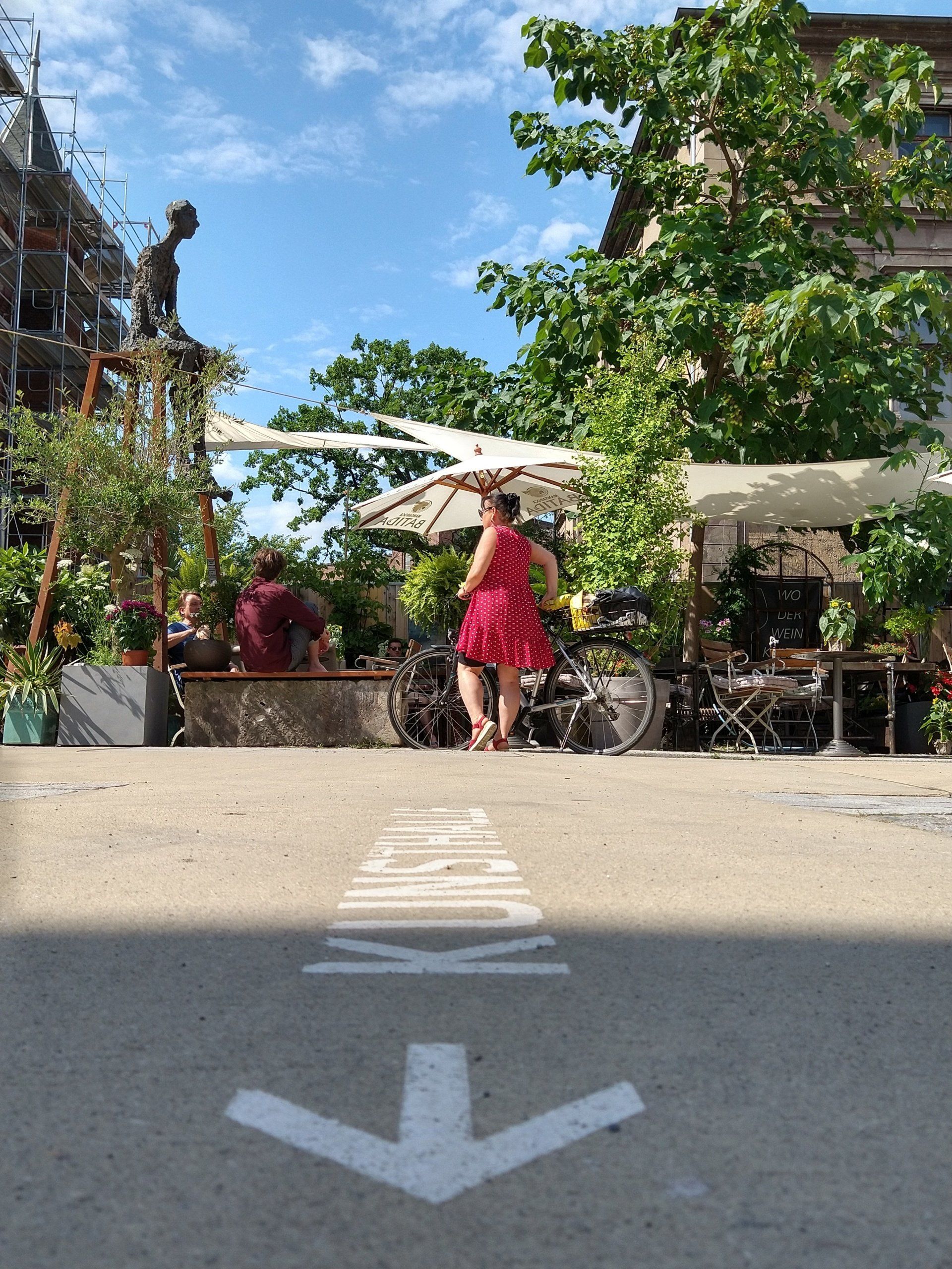 Sommergarten des T1 und das grüne Herz des Kraftwerk Mitte mit der Bronzefigur 