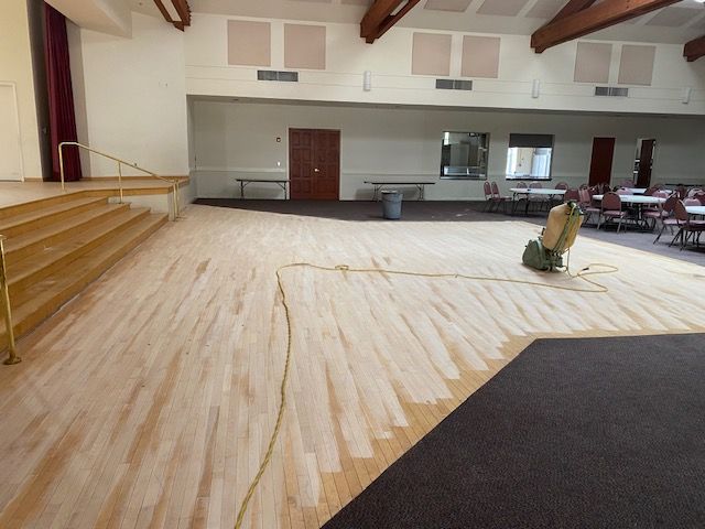 Applying hardwood floor stain during a restoration project