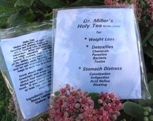 Herbal tea packages with pink flowers and green leaves, labeled for weight loss and stomach distress