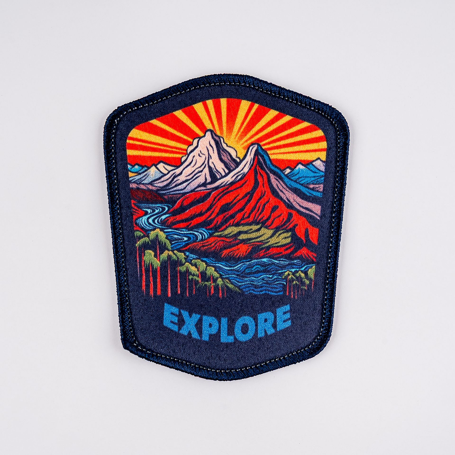 Patch with mountain landscape, orange sunset, blue water, and