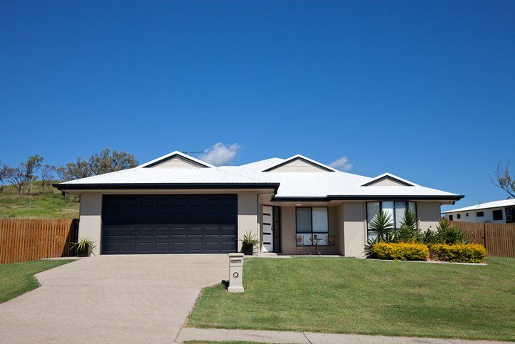 A house with a white roof and a black garage door