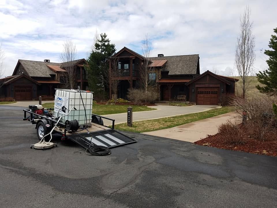 Wheelchair lift ramp on a driveway in front of a large rustic house.