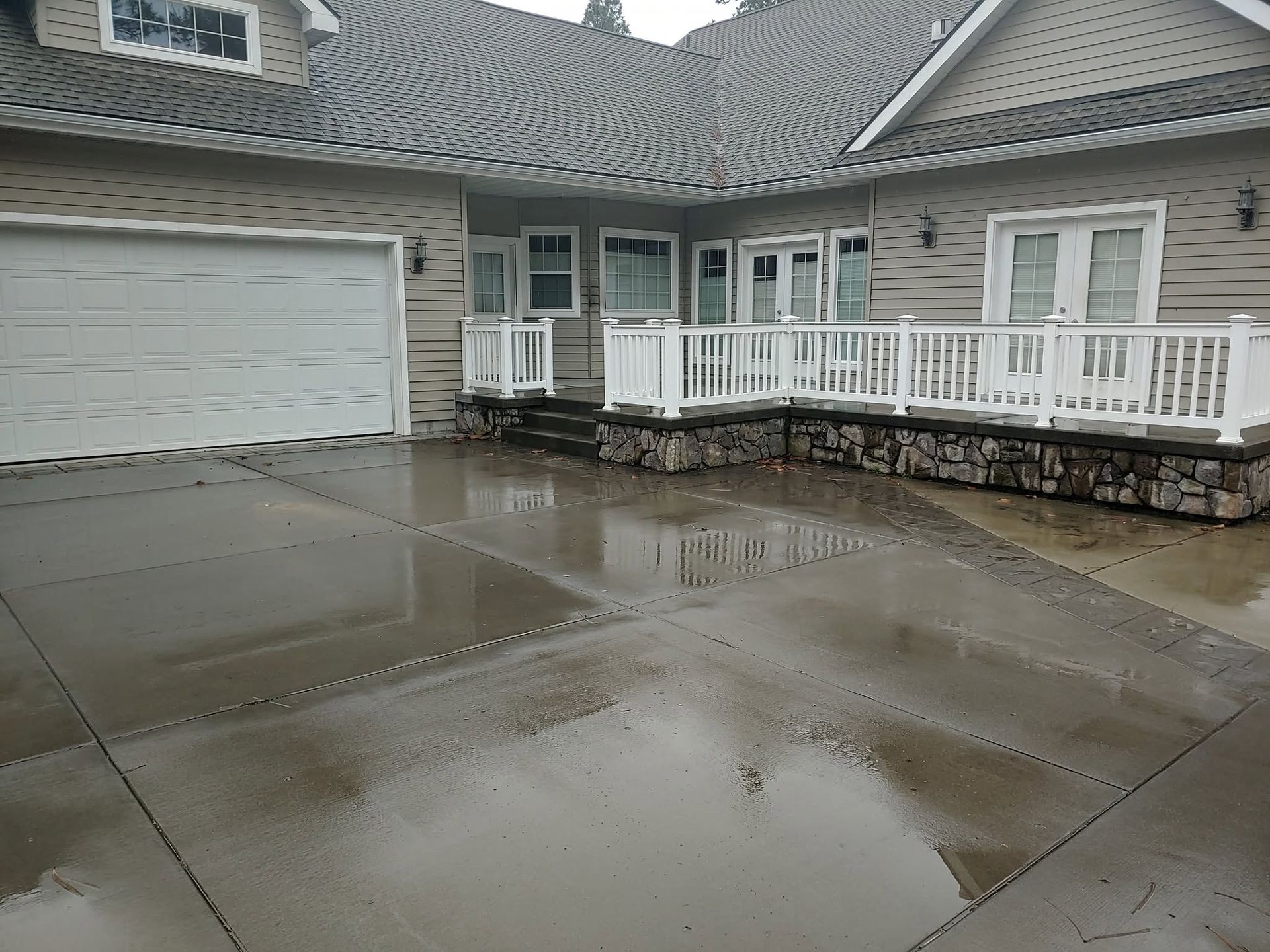 Suburban house with a curved driveway, black pickup truck, and cloudy sky