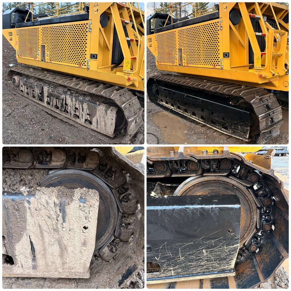 Construction loader with muddy tires being washed beside a yellow bucket