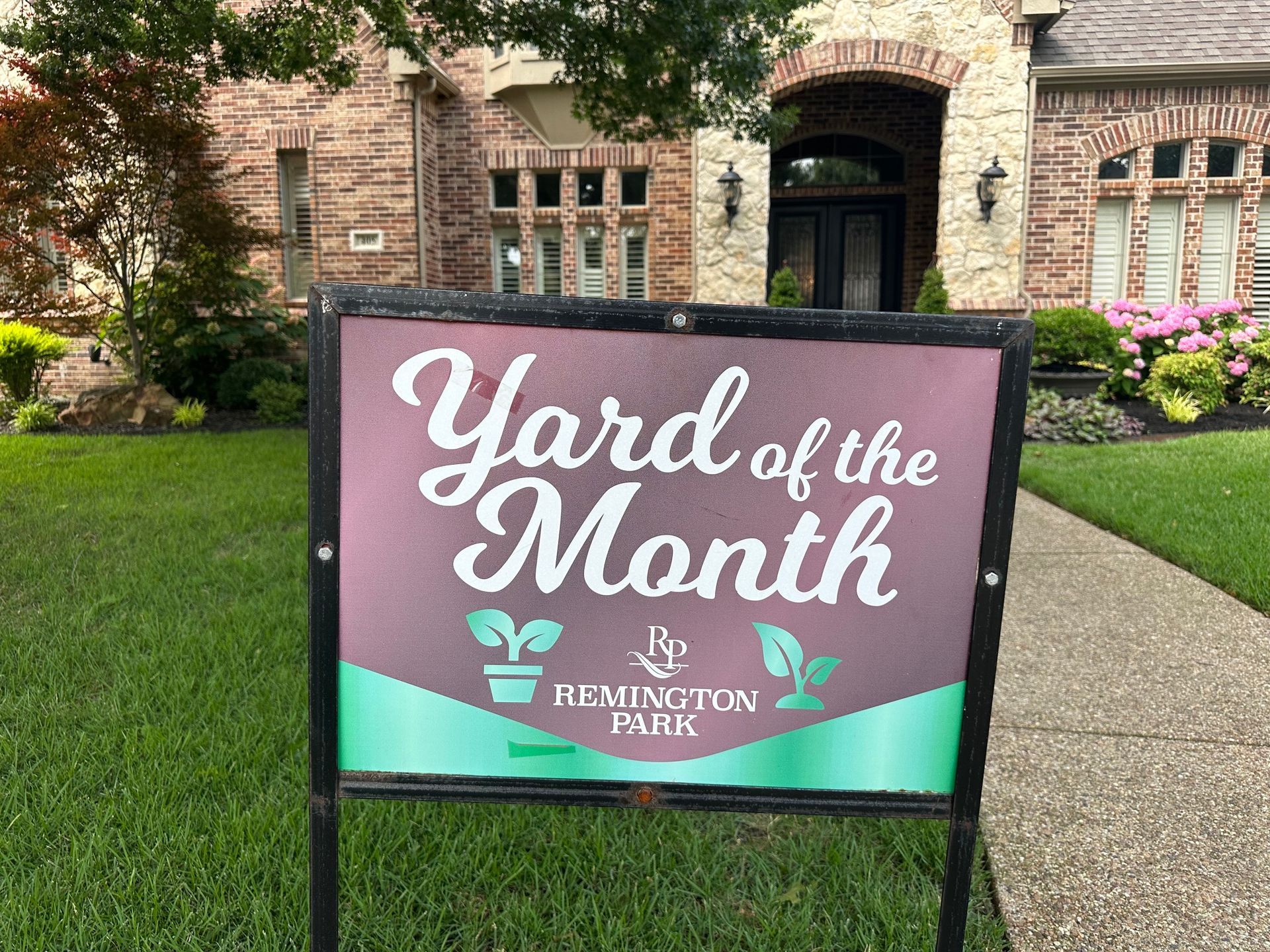 “Yard of the Month” sign on a lawn in front of a brick Colleyville home in the Remington Park neighborhood.  