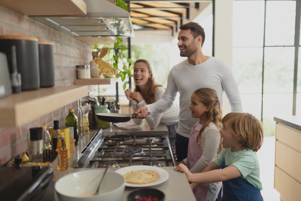 Happy Caucasian Family Preparing Food — Plumbers in Harlaxton, QLD