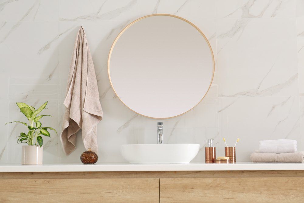 Bathroom With Round Mirror — Plumbers in Harlaxton, QLD