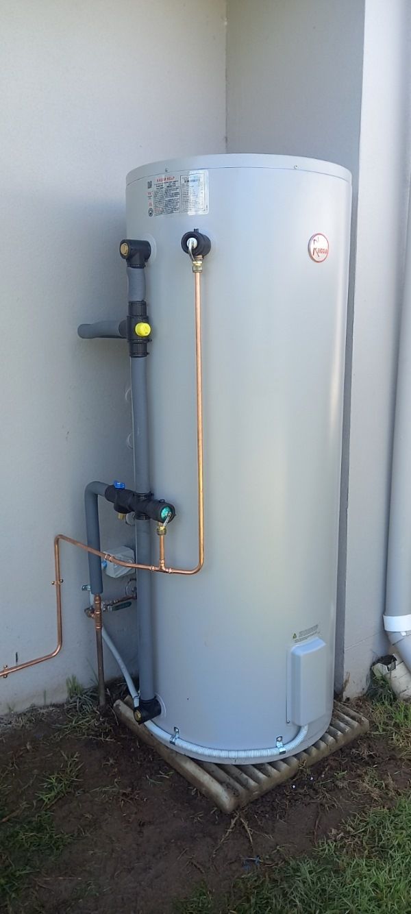 Large Cylindrical Water Heater Outdoors With Pipes