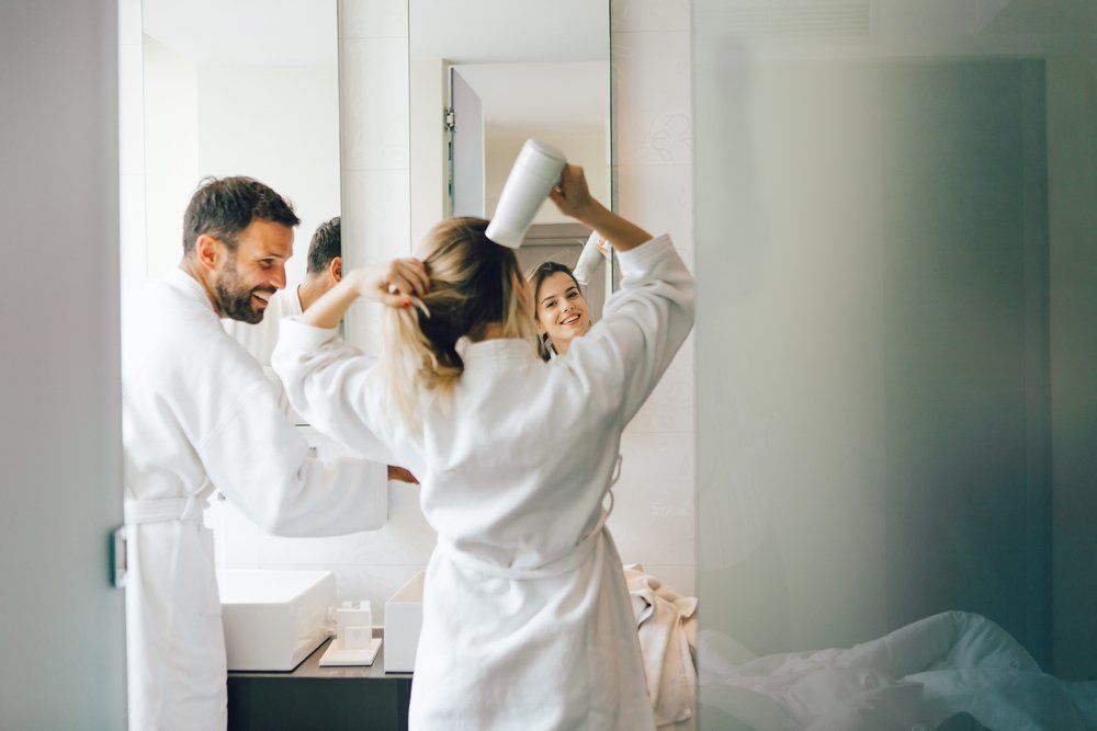 Young Woman Blow-drying Hair — Plumbers in Harlaxton, QLD