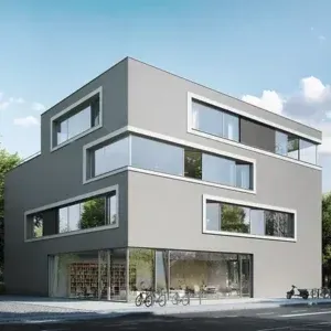 Moderno edificio grigio con grandi finestre rettangolari, biciclette e vetrina, alberi sullo sfondo.