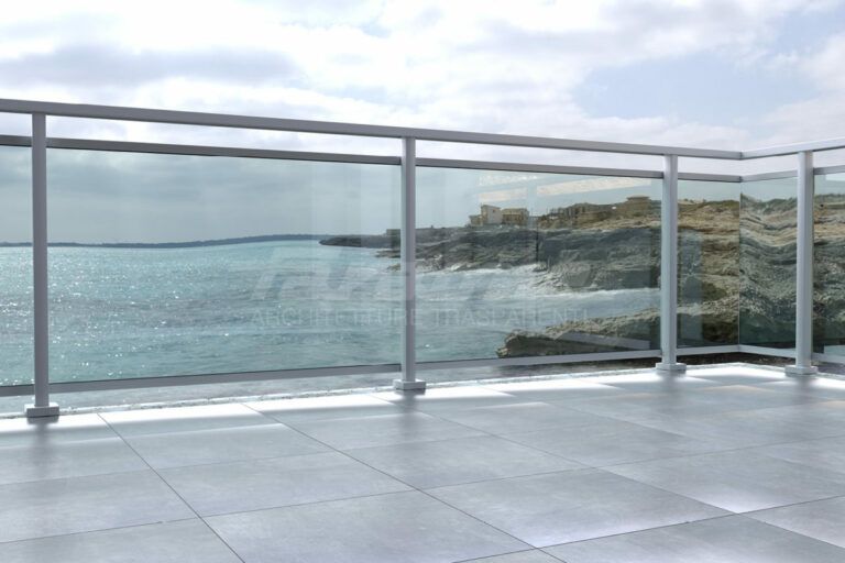 Un balcone con ringhiera in vetro che si affaccia sulla costa rocciosa e sull'oceano.