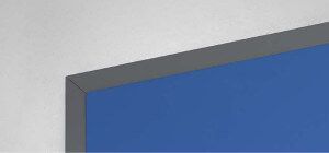 Angolo di una lavagna blu con bordo grigio contro un muro bianco.