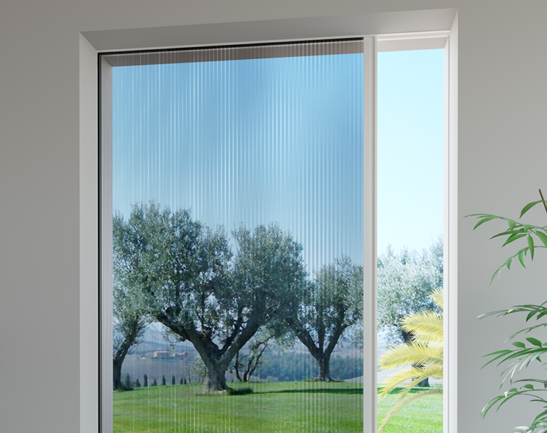Finestra con zanzariera retrattile; vista degli alberi e del cielo attraverso la zanzariera.