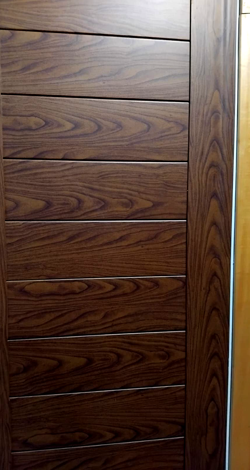 Porta in legno con pannelli orizzontali, colore marrone scuro, con texture effetto legno.