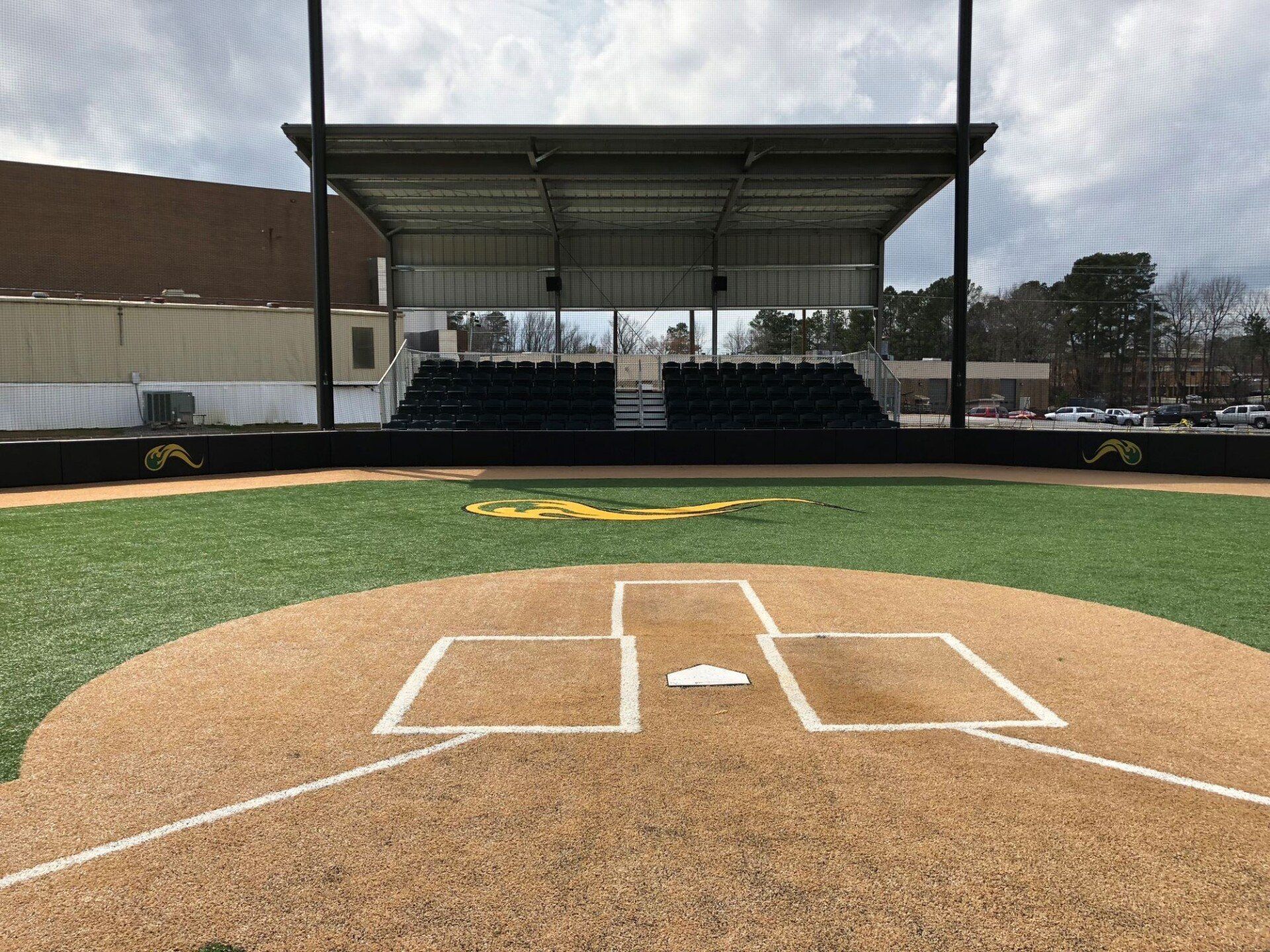 Empty baseball field with home plate and bleachers under a covered grandstand