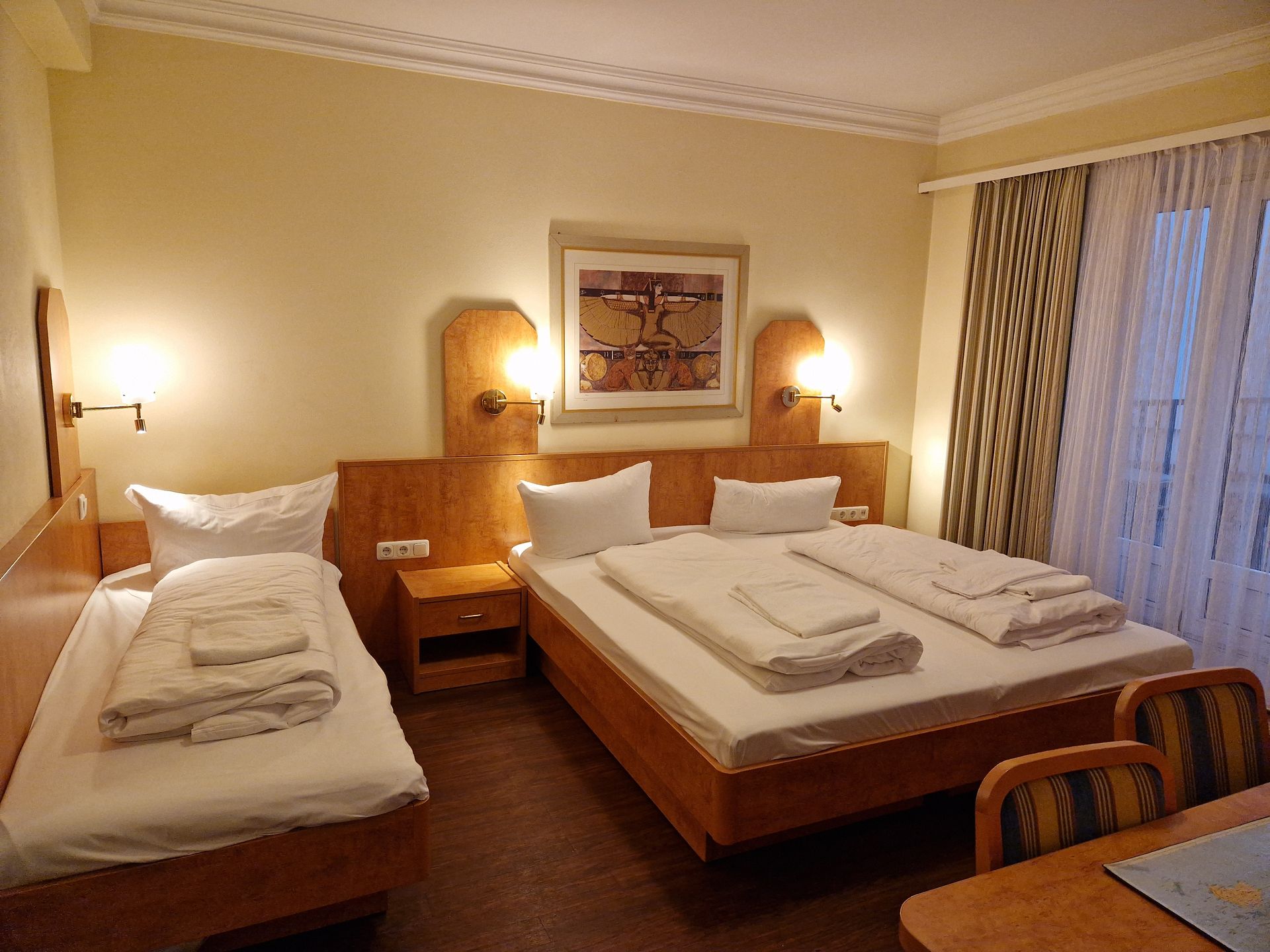 Ein Hotelzimmer mit drei Betten und einem Tisch