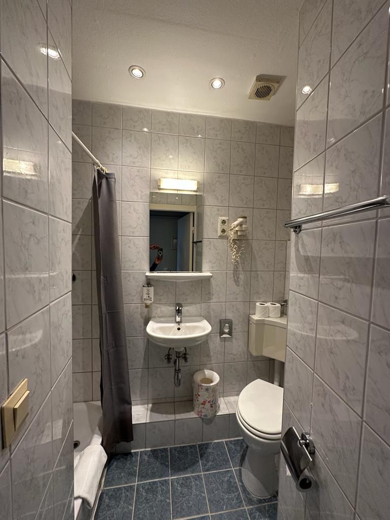 Ein Badezimmer mit Toilette, Waschbecken und Spiegel