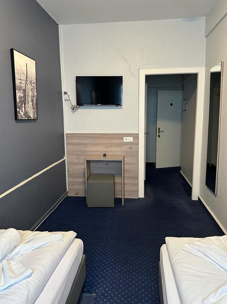 Ein Hotelzimmer mit zwei Betten und einem Flachbildfernseher