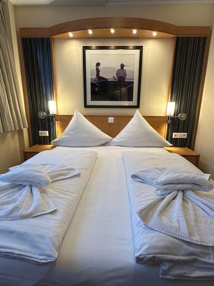 Ein Hotelzimmer mit zwei Betten und einem Bild an der Wand über dem Bett.