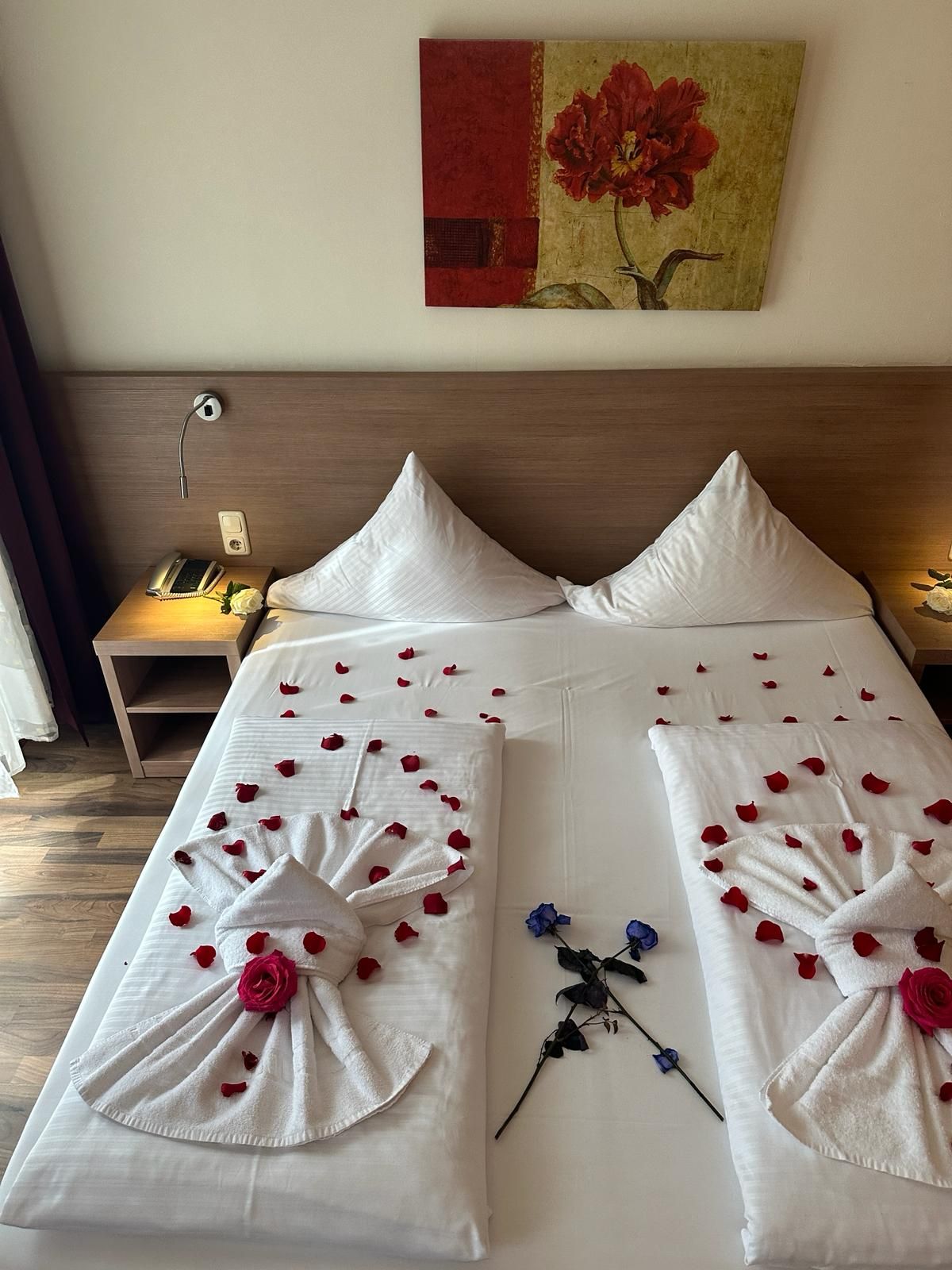 Ein Hotelzimmer mit einem mit Rosen und Handtüchern dekorierten Bett