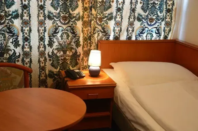 Ein Hotelzimmer mit einem Einzelbett und einem Tisch