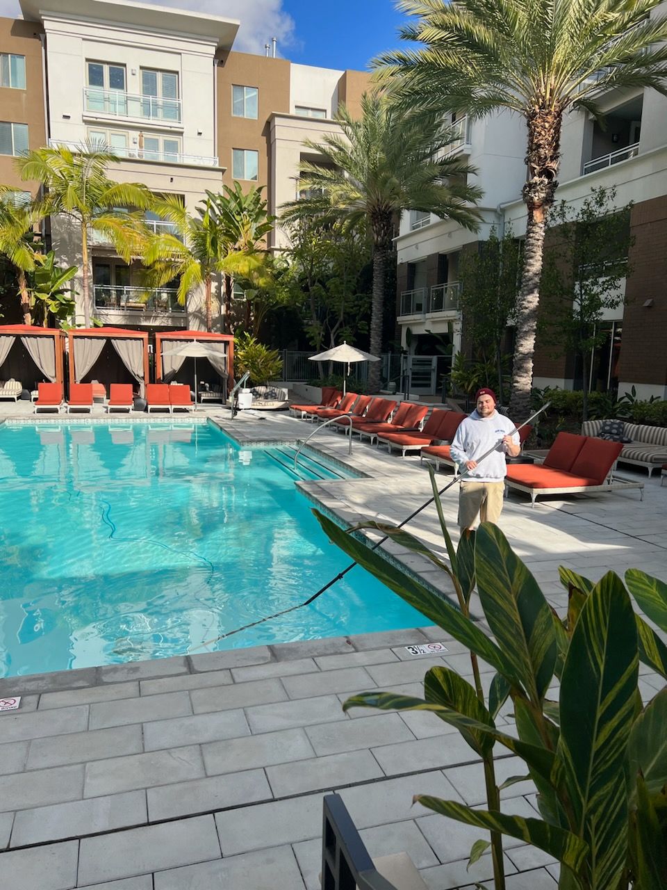 A man is standing in front of a large swimming pool