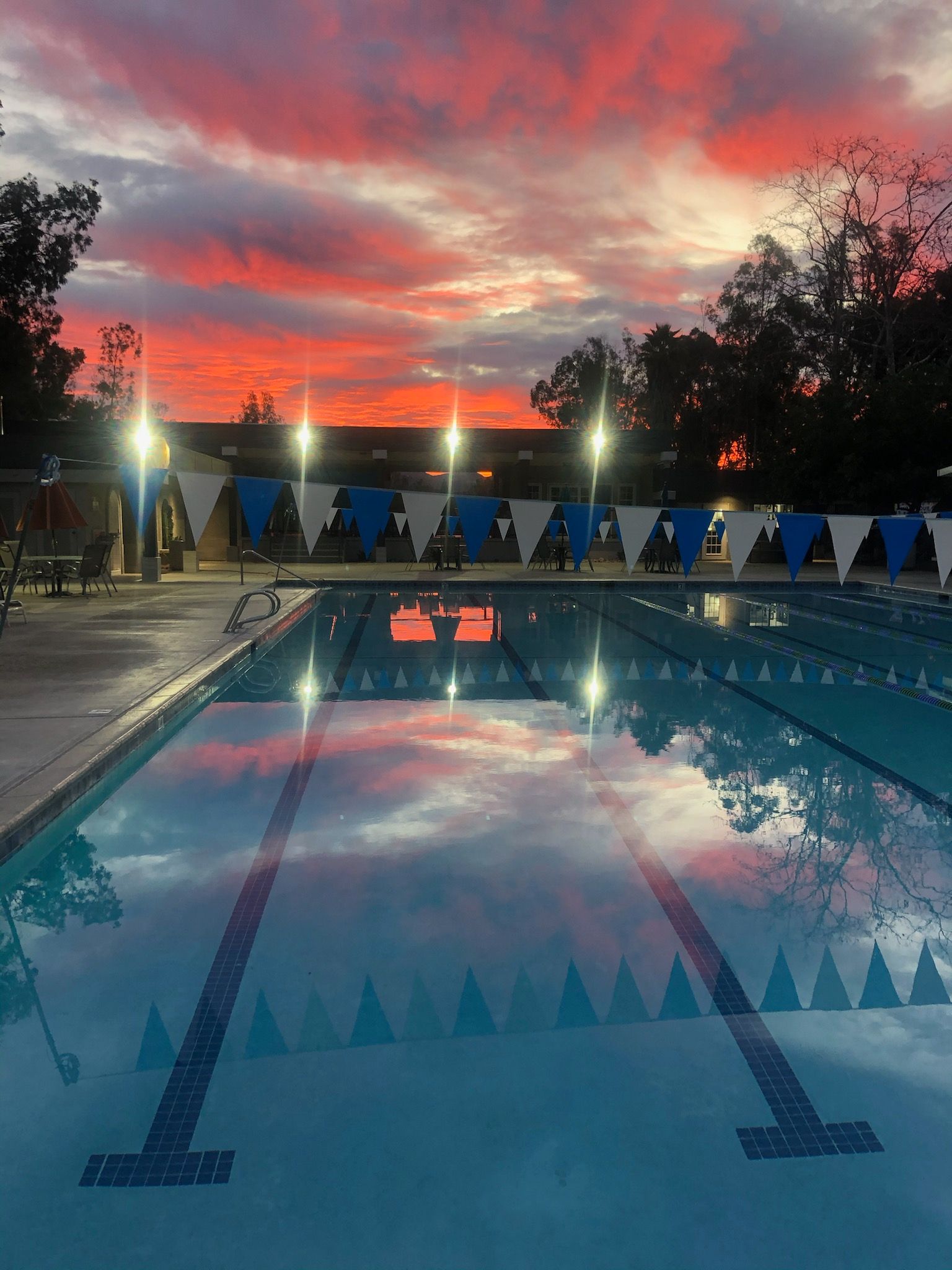 A large swimming pool with a sunset in the background