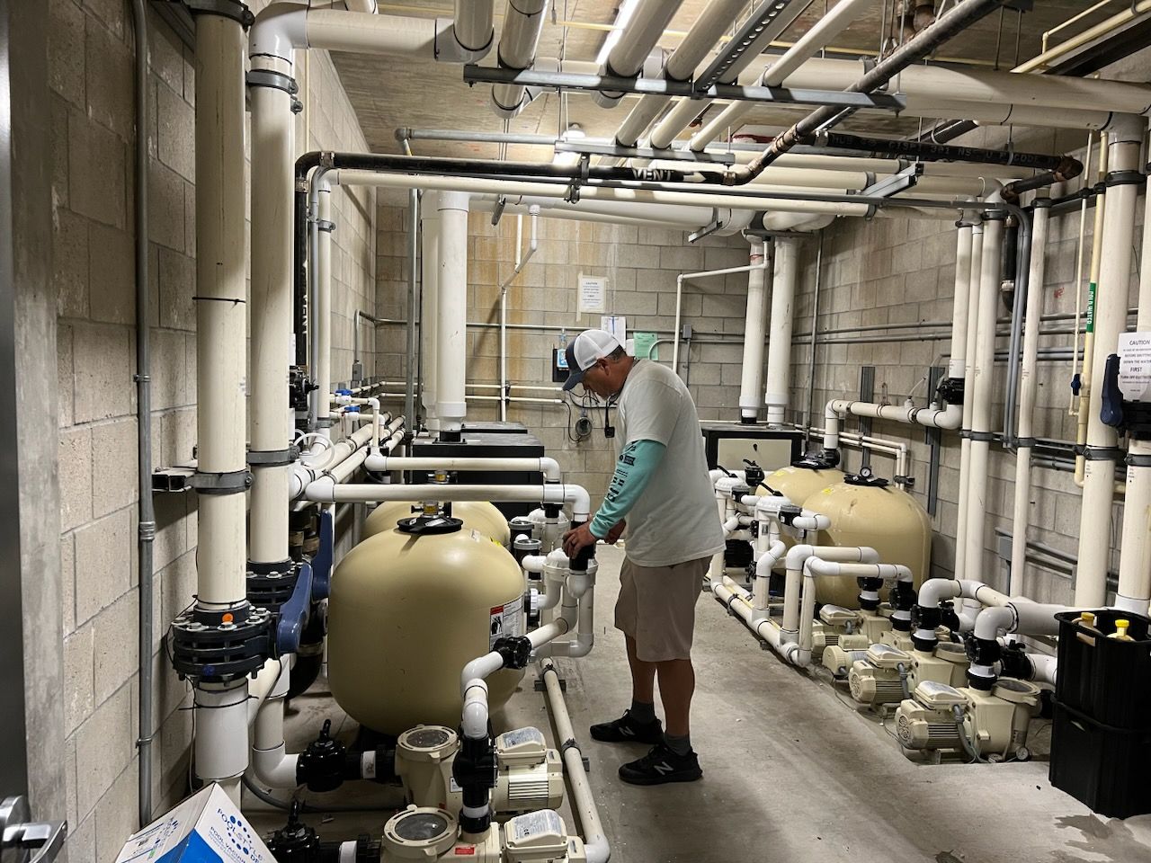 A man is working on a swimming pool in a warehouse.