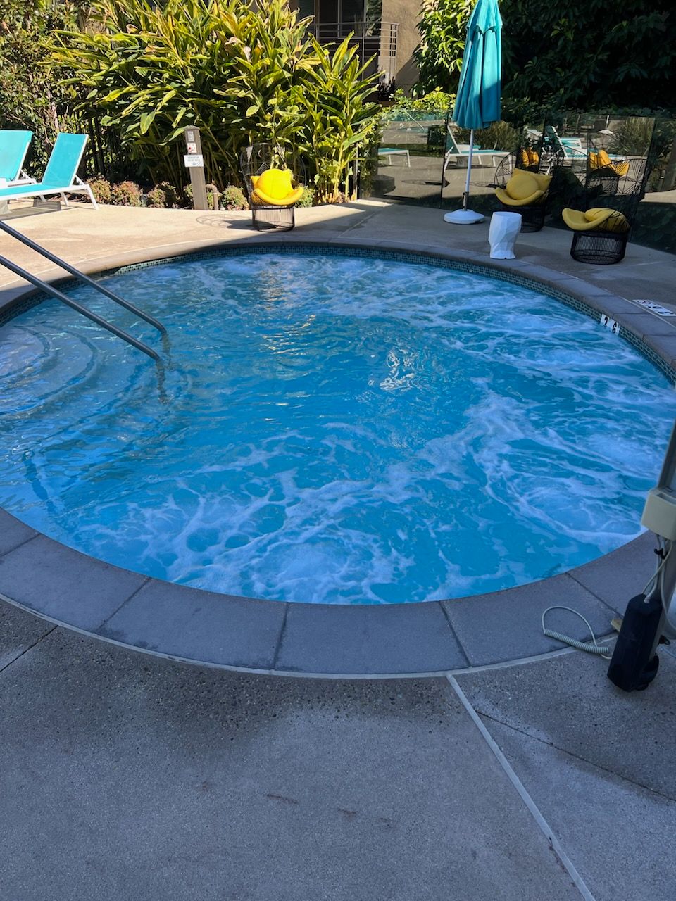 A swimming pool with chairs and umbrellas around it