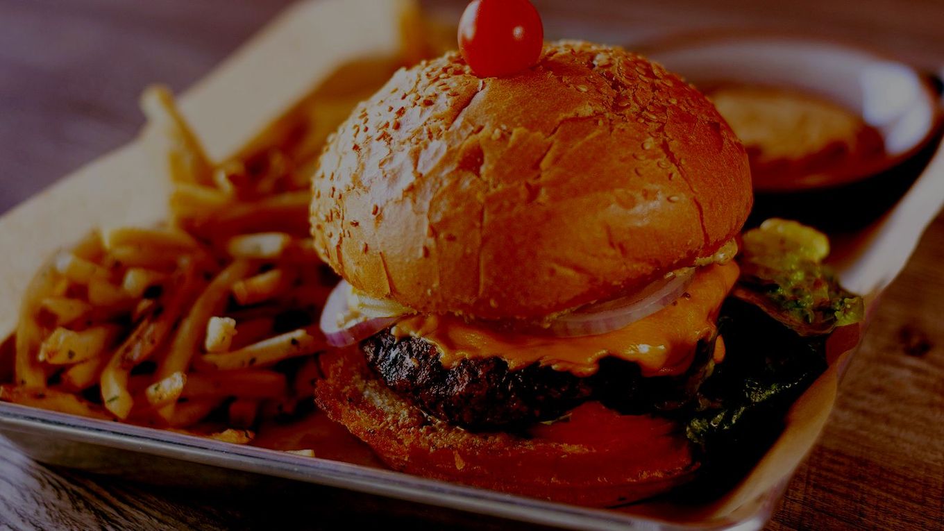 A hamburger and french fries on a tray on a table.
