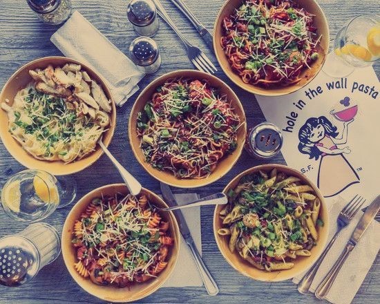 A table topped with bowls of pasta and a napkin that says 