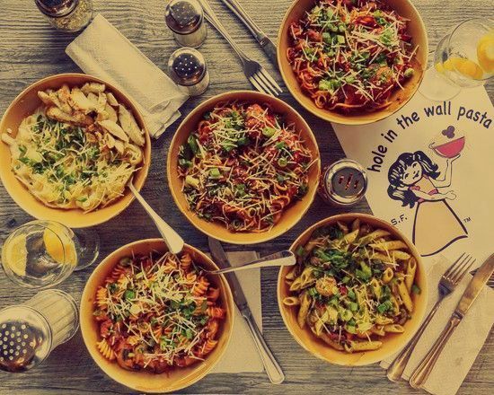 A table topped with bowls of pasta and a napkin that says