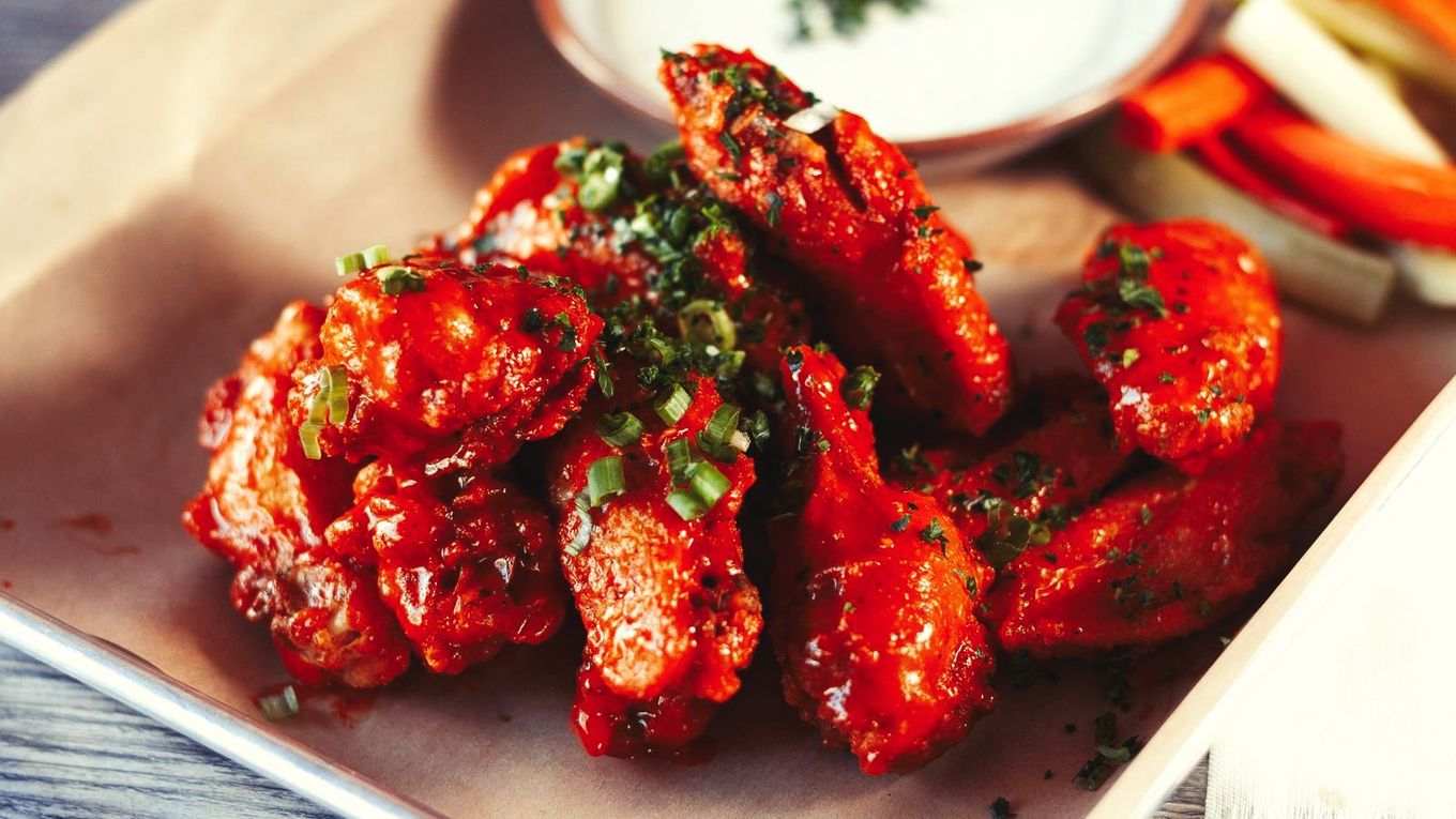 A close up of a plate of chicken wings on a table