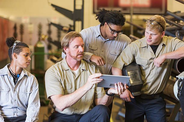 Three students and an instructor at HVAC Technical Institute, a trusted trade school in Chicago, IL, during a hands-on lesson