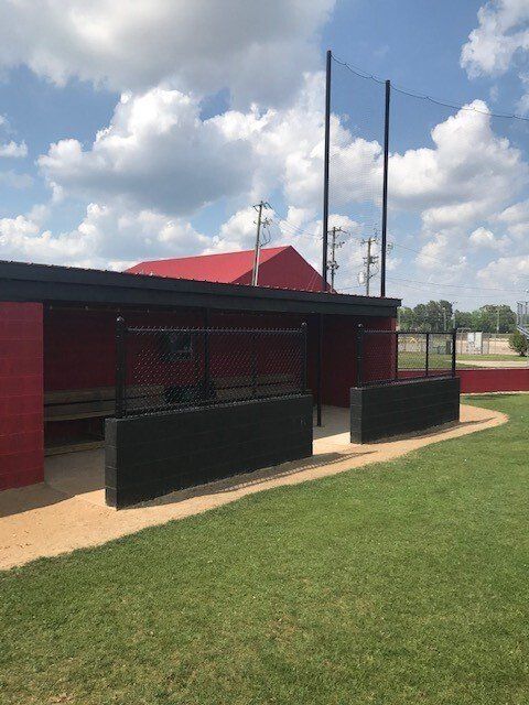 A baseball dugout with a red roof and black walls