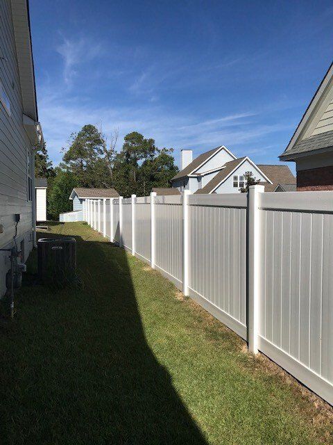white vinyl privacy fence running between two houses