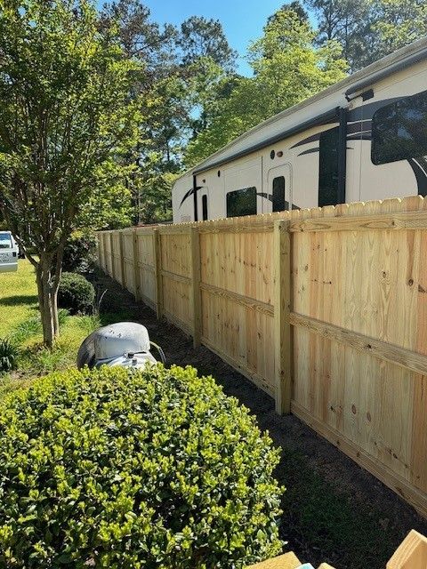 A wooden fence with a trailer in the background