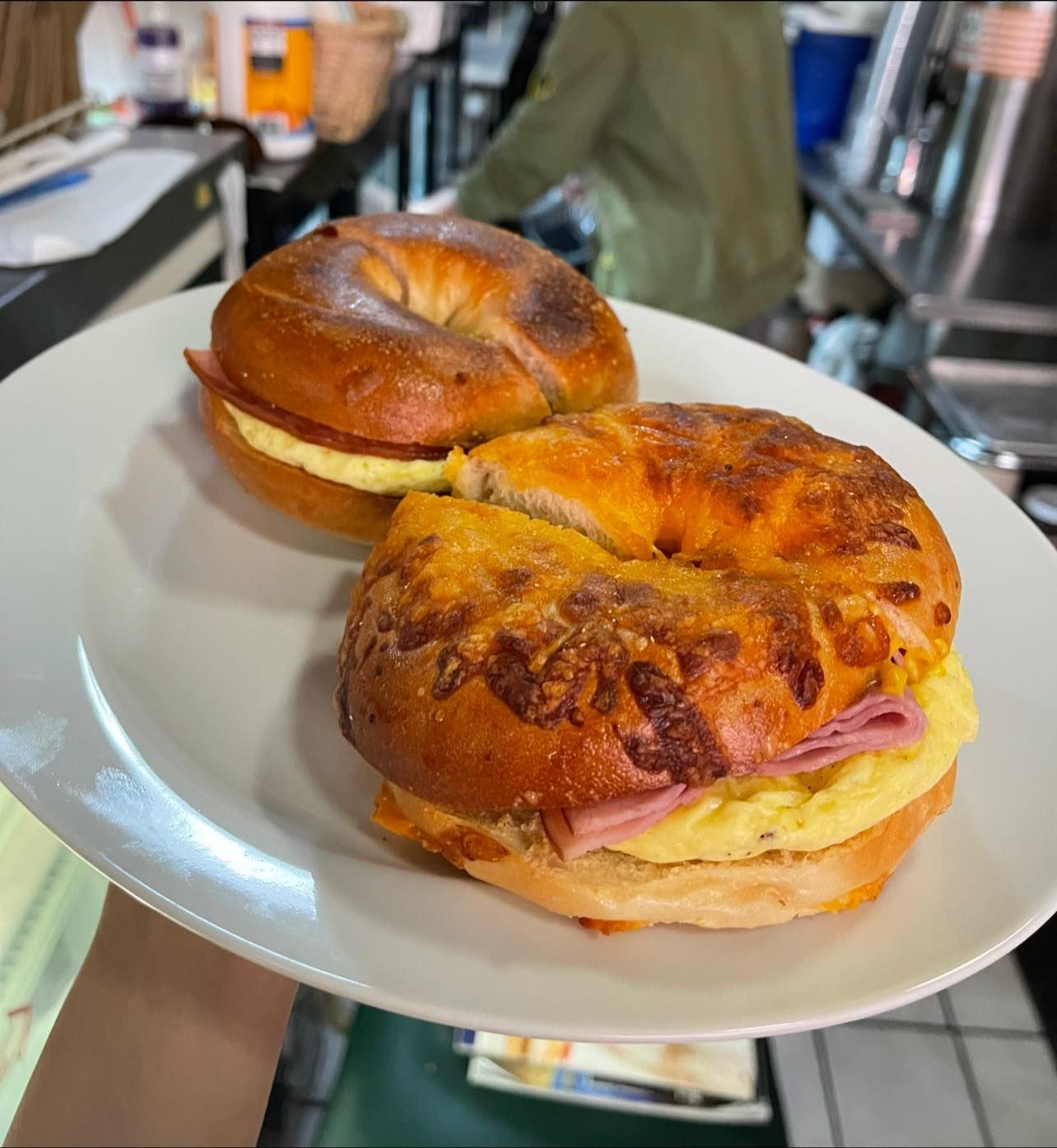 Two toasted sandwiches with melted cheese on a white plate on a table
