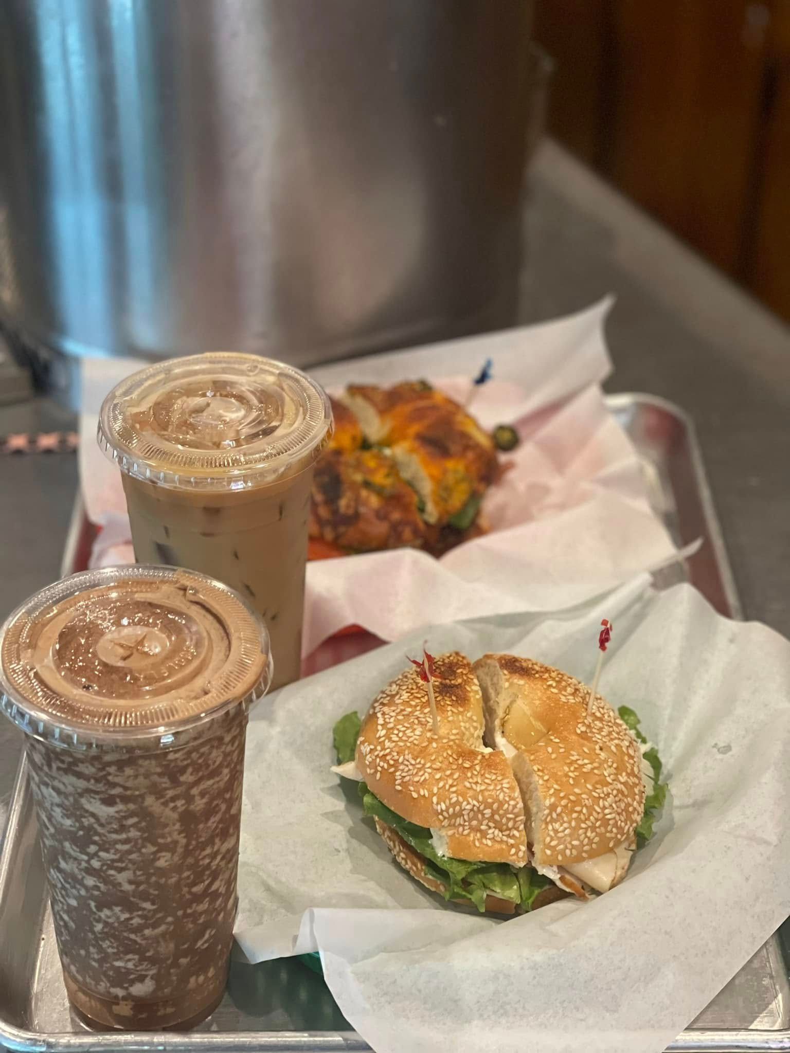 Two iced drinks and two sandwiches on a tray with napkins