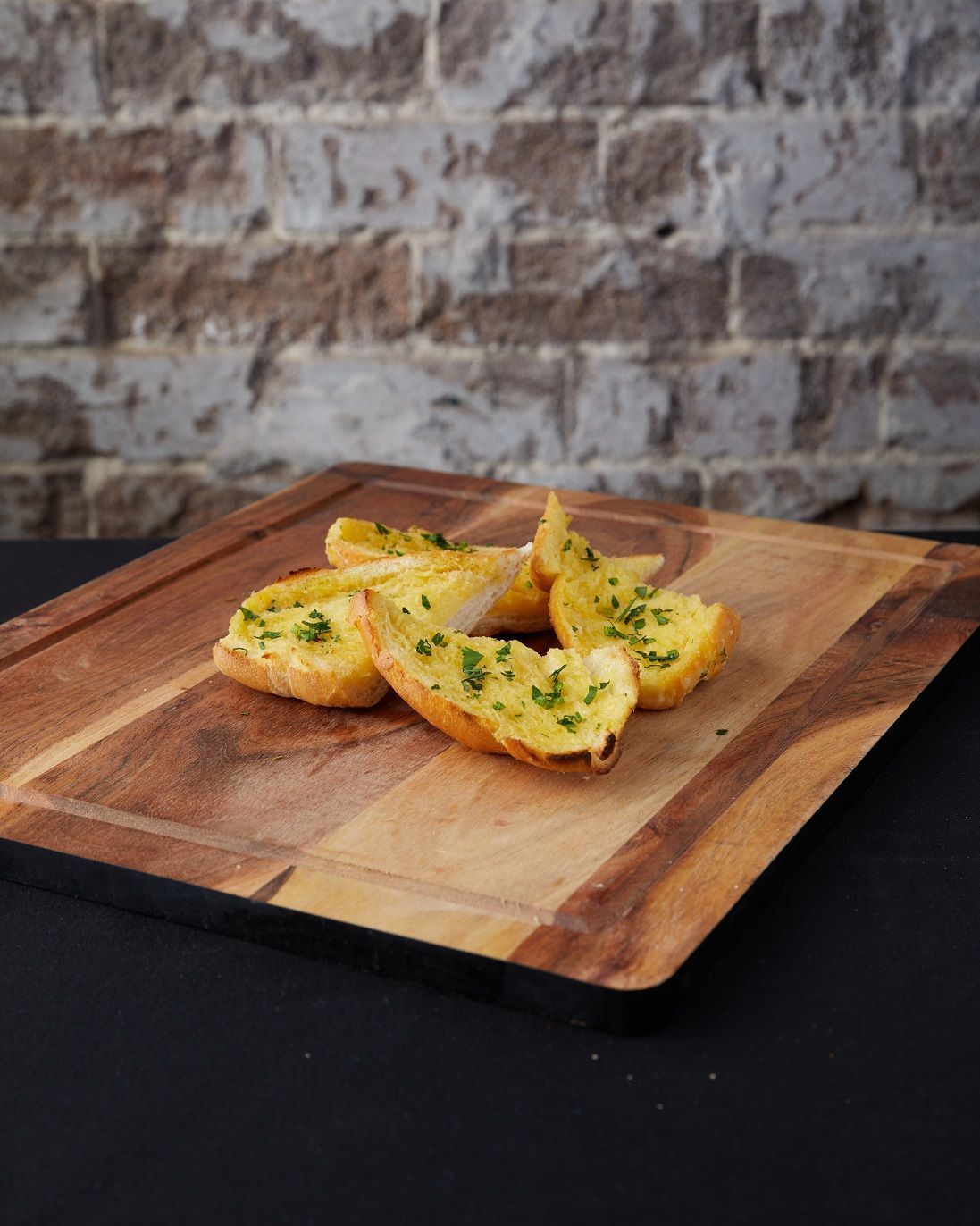 slices of garlic bread on a wooden cutting board