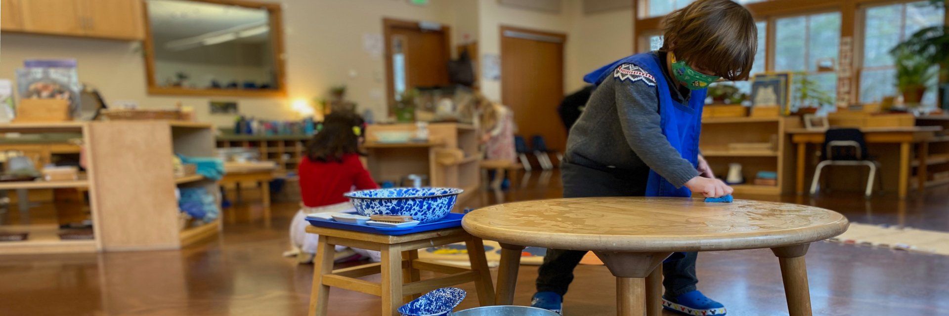 Preschool aged child washing a table