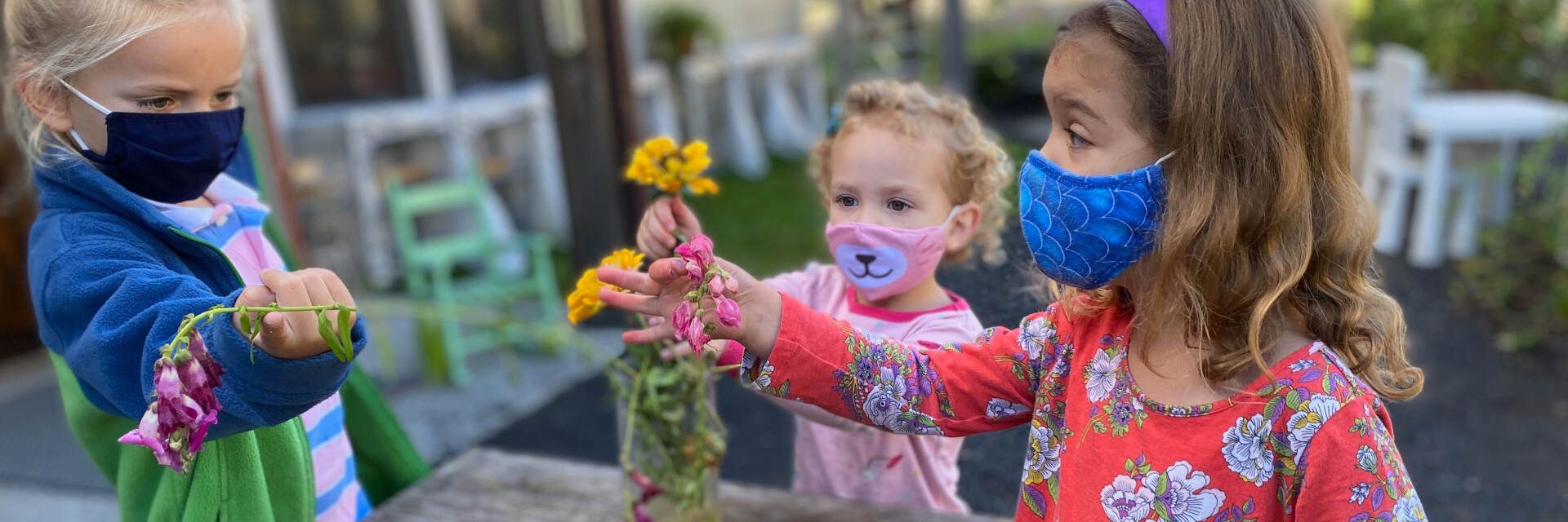 Three preschool aged children arranging flowers