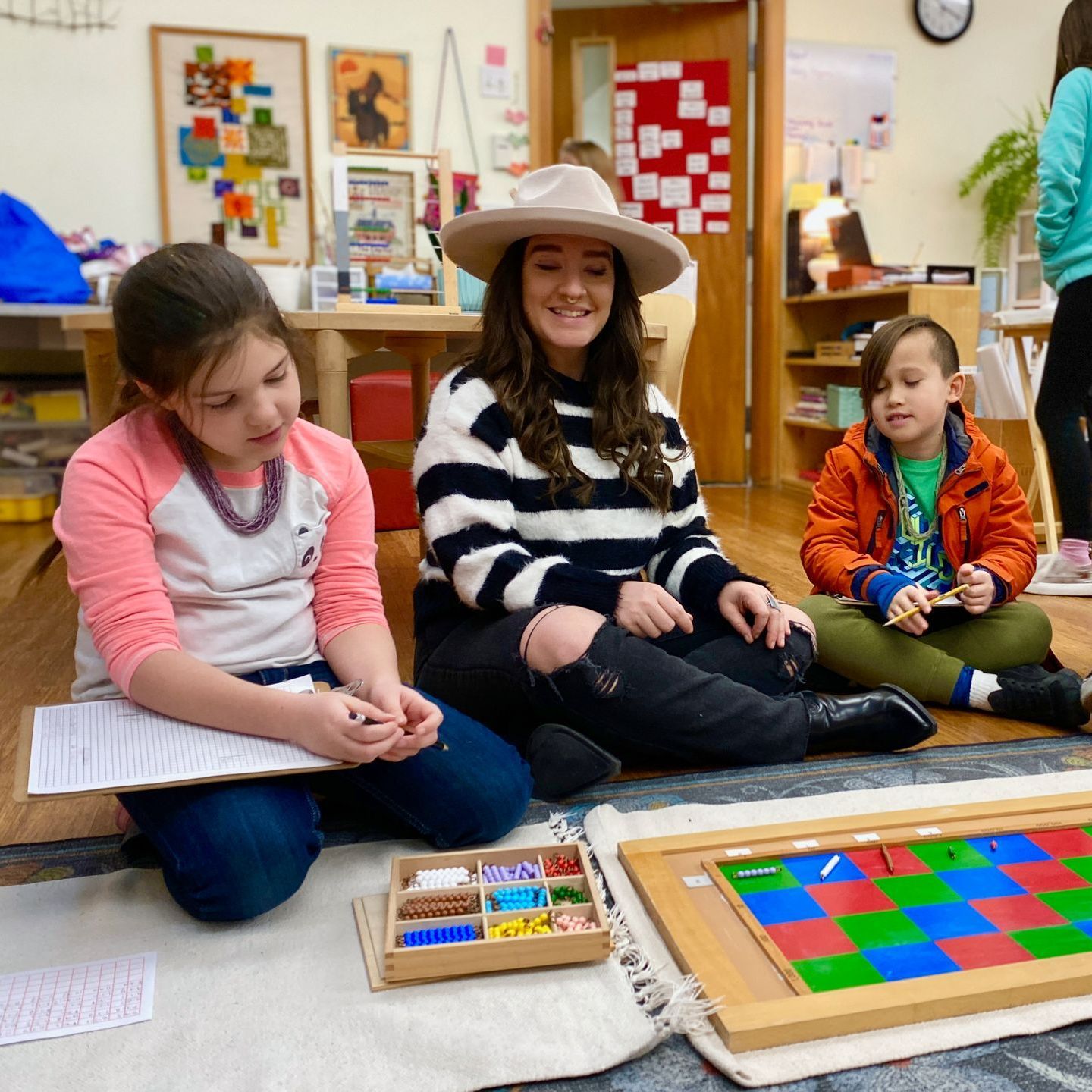 Children's House (preschool) child painting outdoors at easel