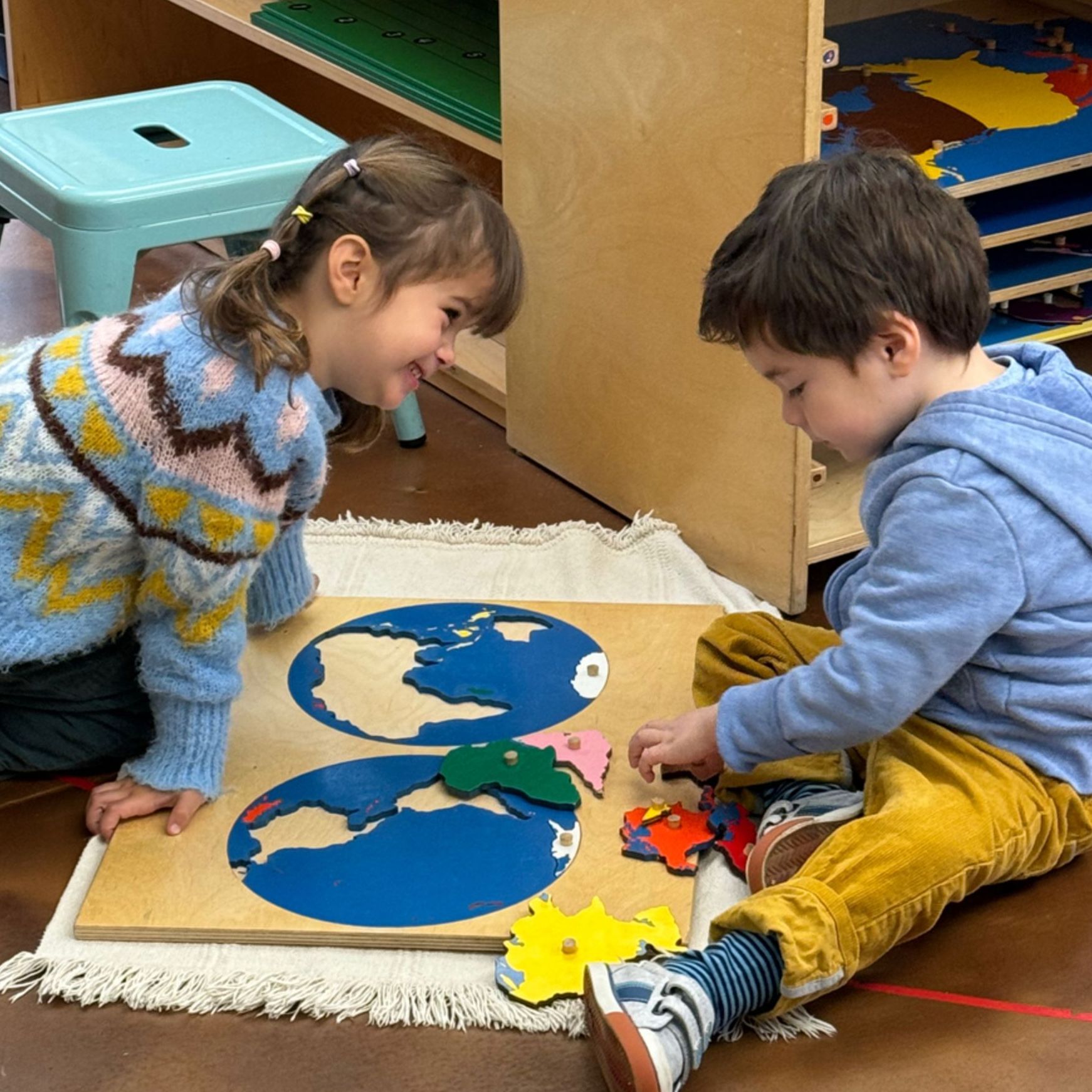 Two Children's house children on the floor with a puzzle map