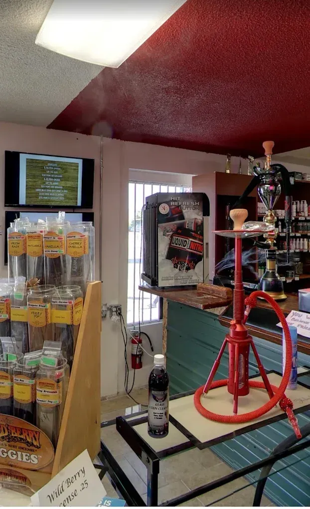 Convenience store checkout area with drink cooler, snack display, and red bicycle stand