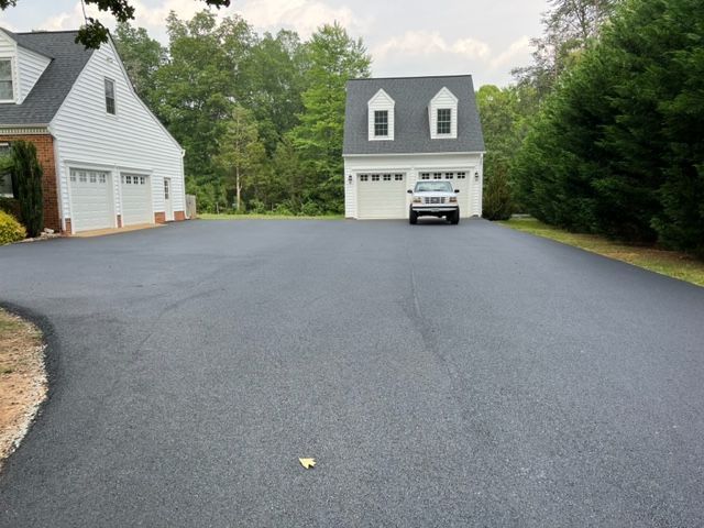 A car is parked in a driveway in front of a house.