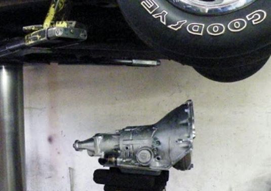 A goodyear tire is sitting under a car